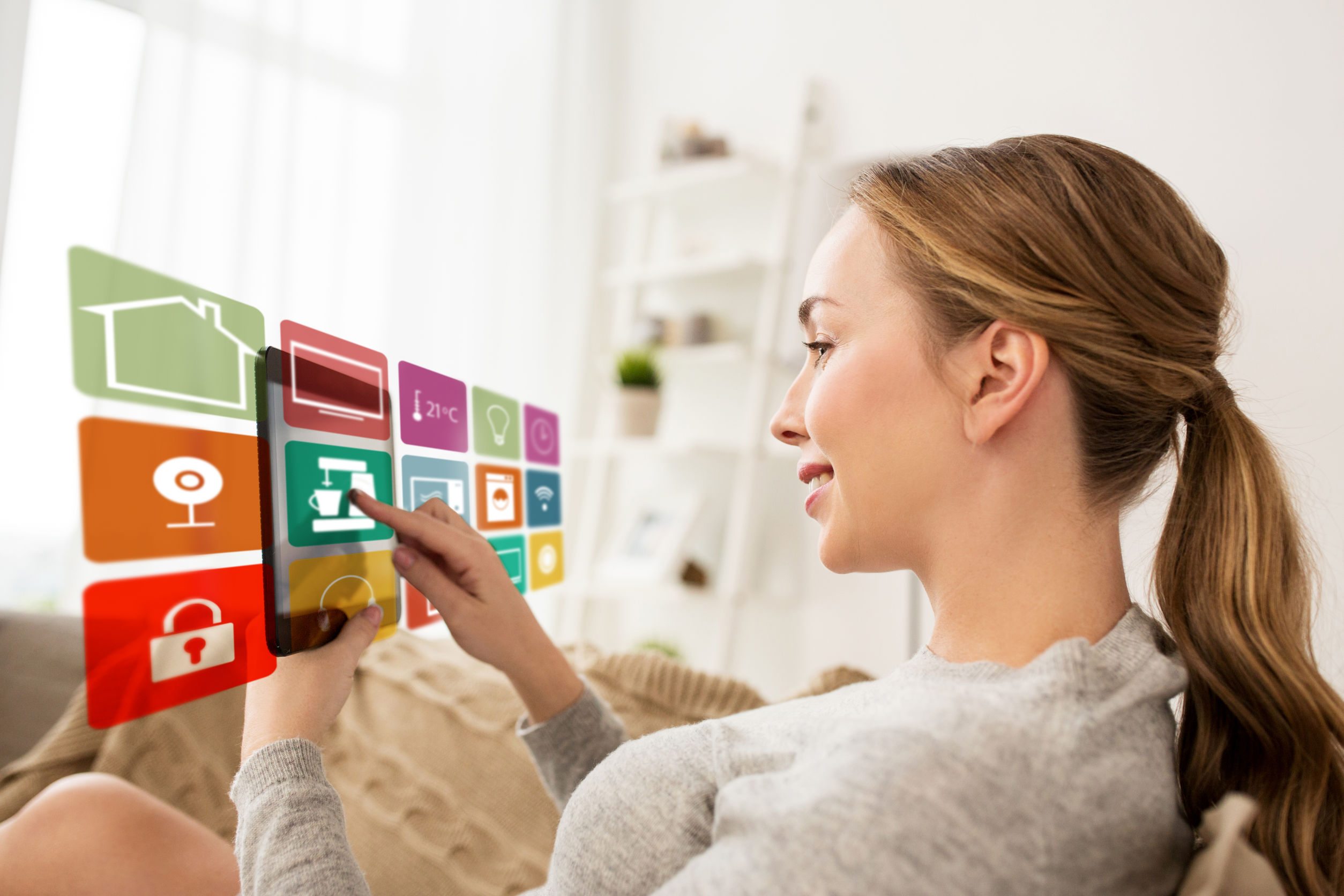 Home Automation Solutions - Women holding tablet and choosing automation settings